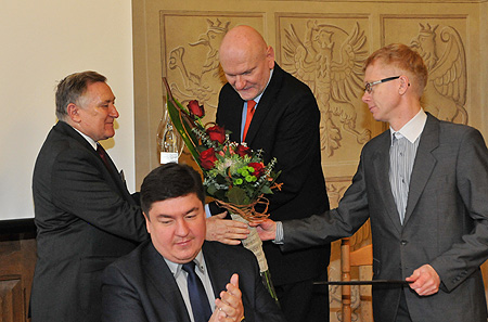 Prezydent Torunia wręcza prof. Łapiczowi statutkę szklanego anioła